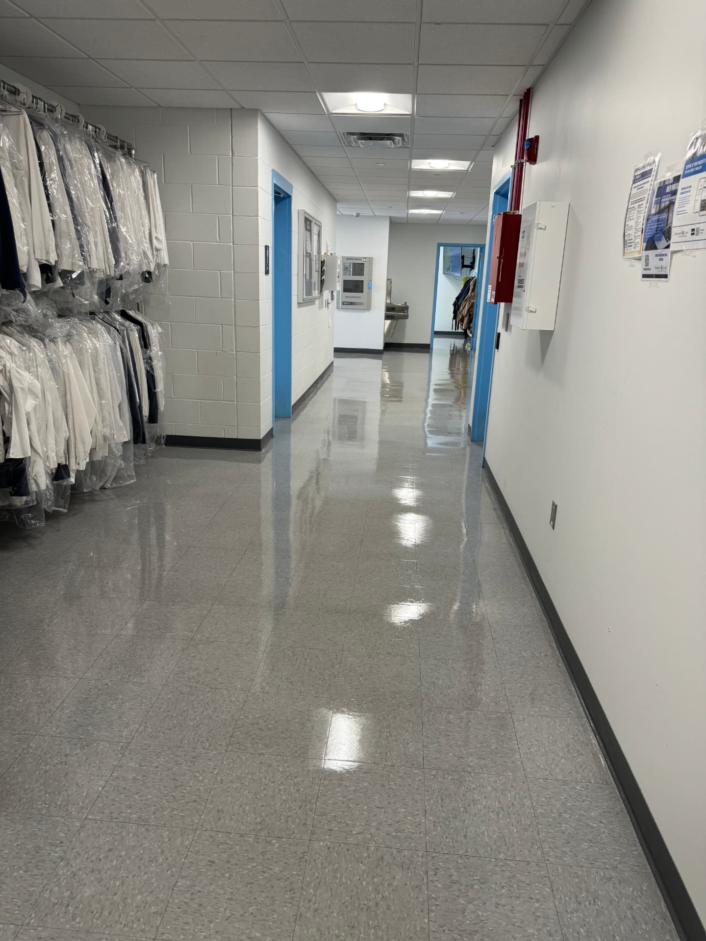 Freshly polished hallway floor lined with garment racks
