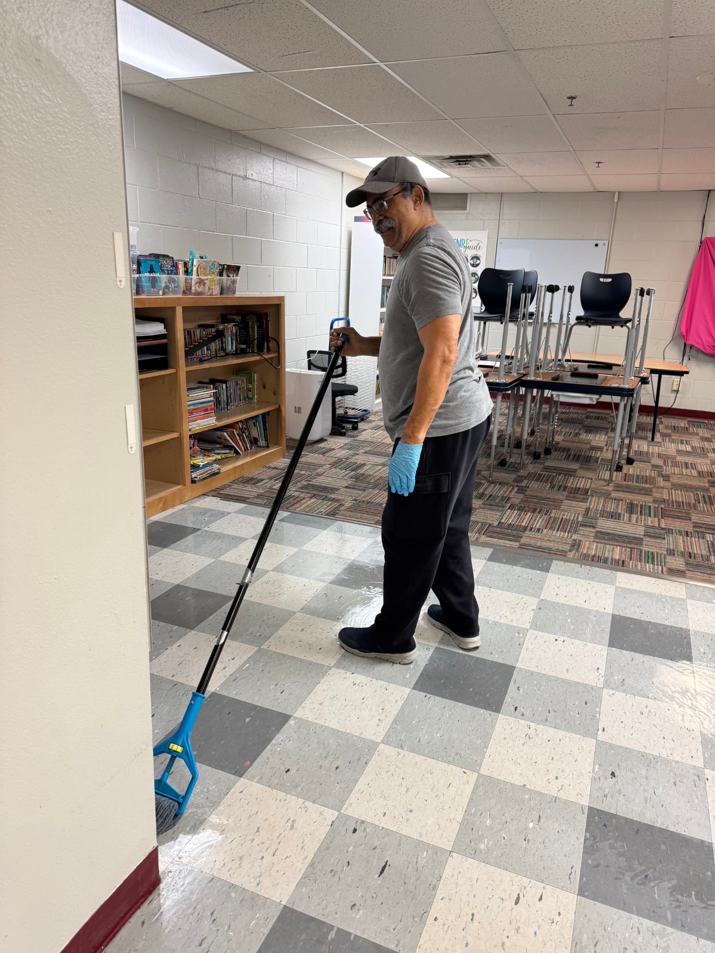 Team member mopping a school classroom floor