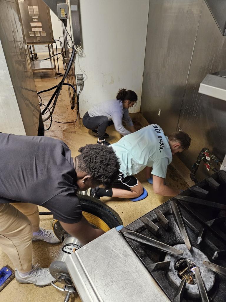 Team deep cleaning a commercial kitchen floor