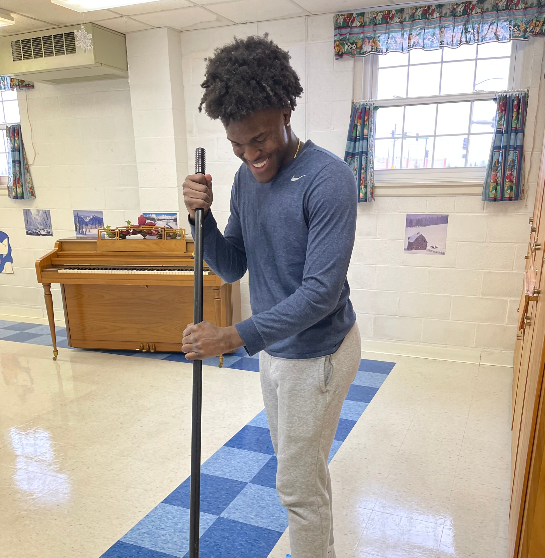 Team member dust mopping a preschool classroom